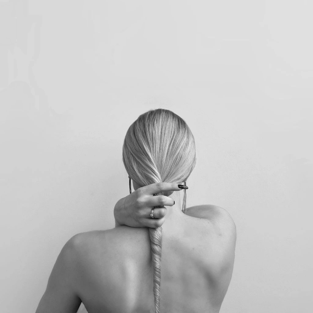 Minimalist crescent moon tattoo behind the ear